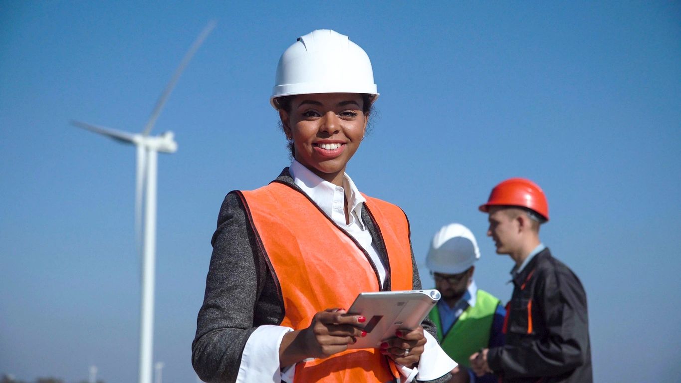 Engineer with tablet at wind farm site.